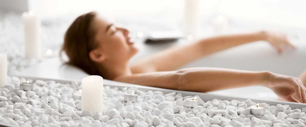 Enjoy Spa Procedure. Woman Lying In Bath With Foam And Candles